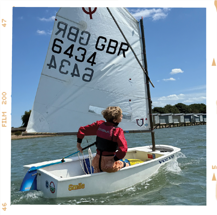 Dingy sailing on a high tide in front of the the Osea Beach Huts